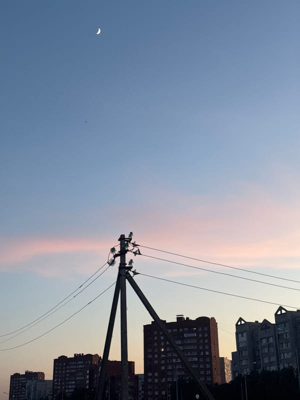 Urban dusk captured by witnesses showing crescent moon, cityscape
