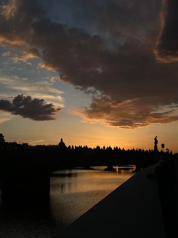 Sunset illuminates Florence's Ponte Vecchio bridge at dusk