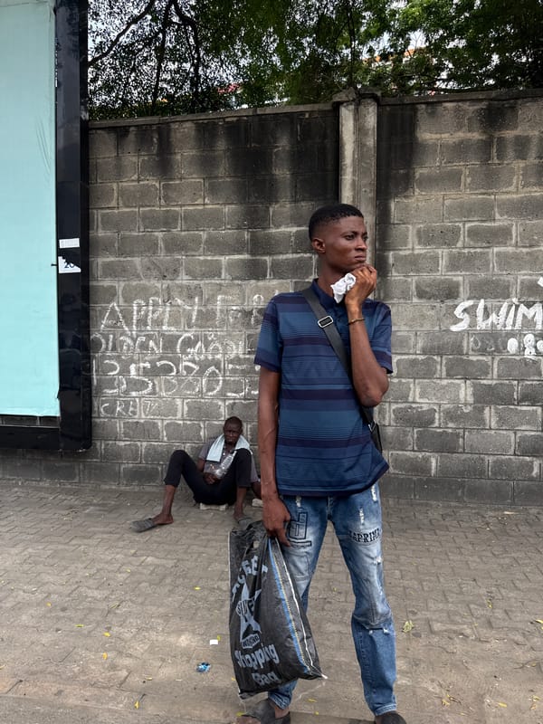 Man holds cloth to face on busy Itirin street