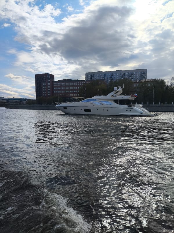 White yacht sails Moscow River past city landmarks