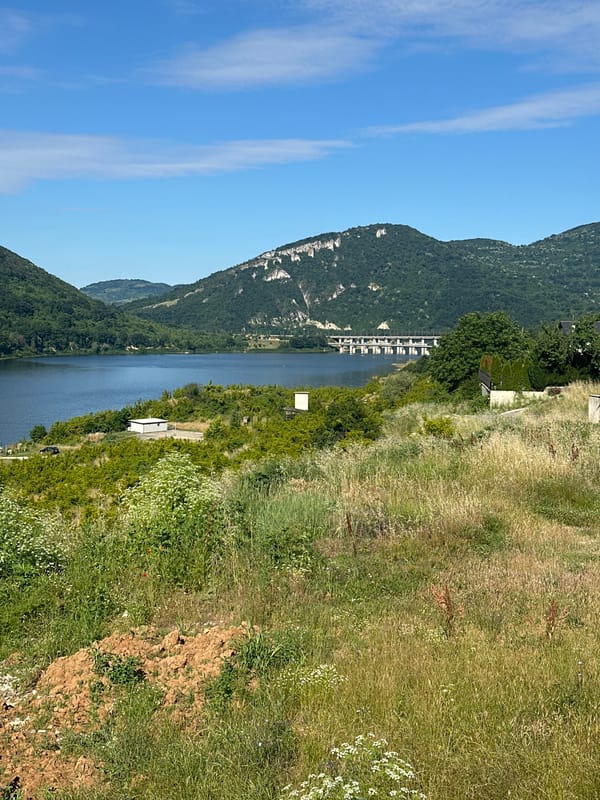 Lakeside pool area amid rolling green hills