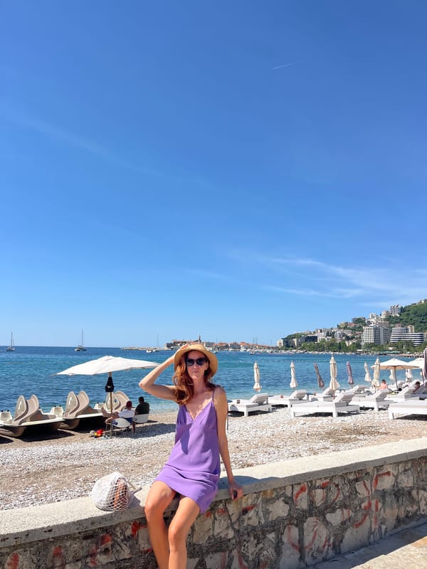 Woman in purple dress enjoys morning at Budva beach