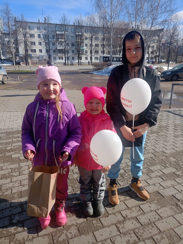 Children gather outside urban building in winter clothing