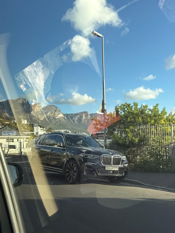 BMW parked on Cape Town road with Table Mountain backdrop