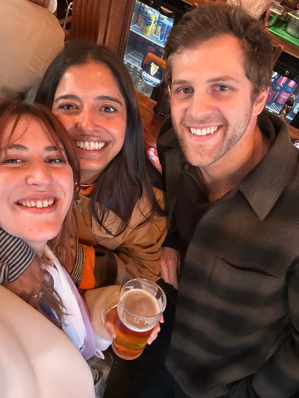 Three friends share drinks at London bar