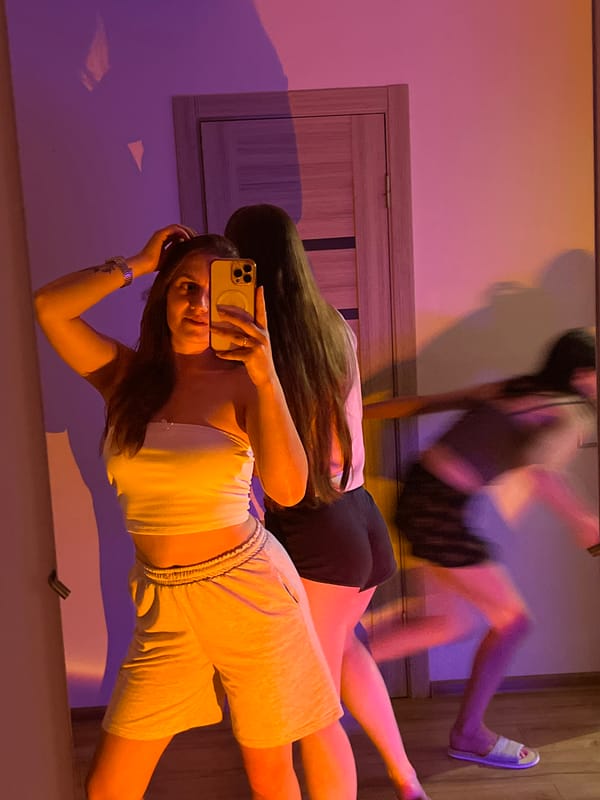 Mirror selfies in a moody, purple-lit room at night