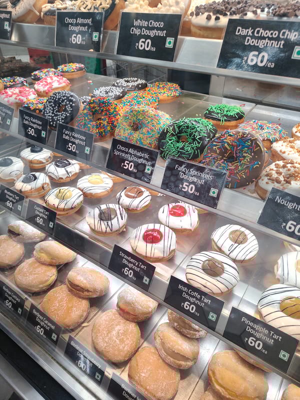Customer surveys dessert displays at Bengaluru bakery during morning visit