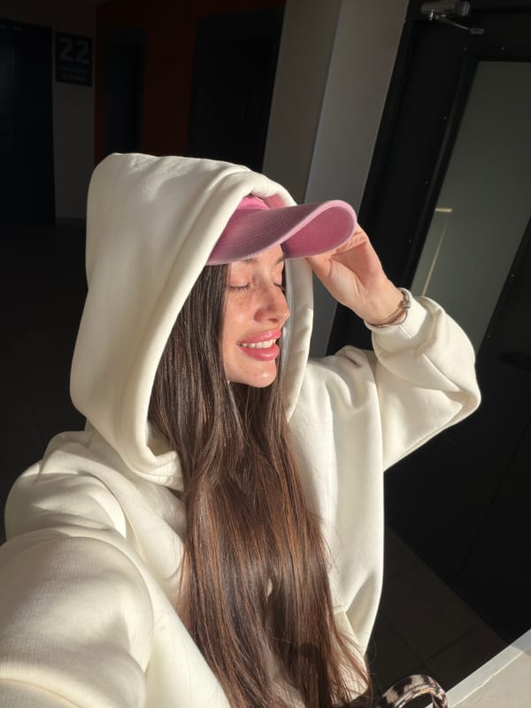 Young woman in pink cap spotted smiling in Saint Petersburg