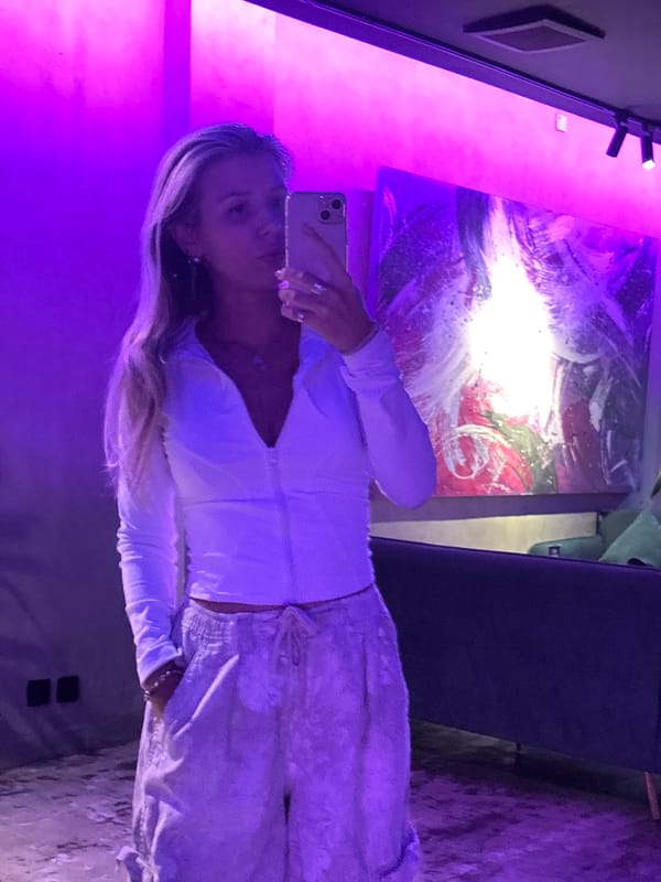 Mirror selfie under moody purple and pink lighting