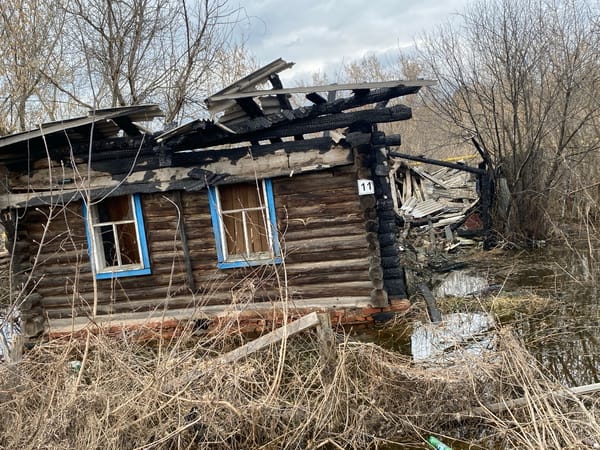 Fire-damaged wooden ruins observed in flooded Pozim' area