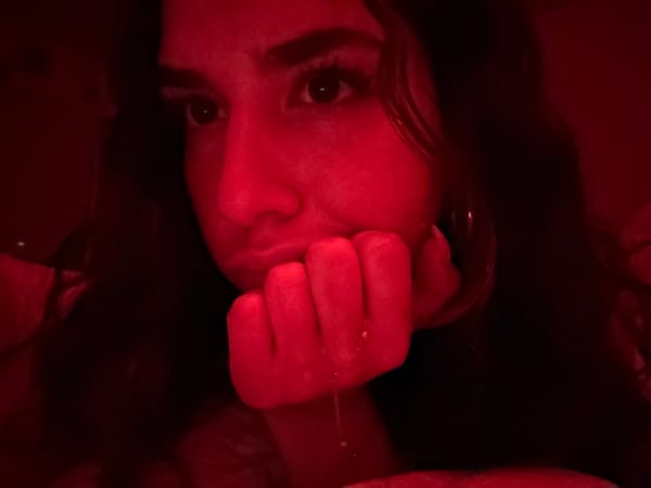 Close-up photo shows face below fist with hanging chain