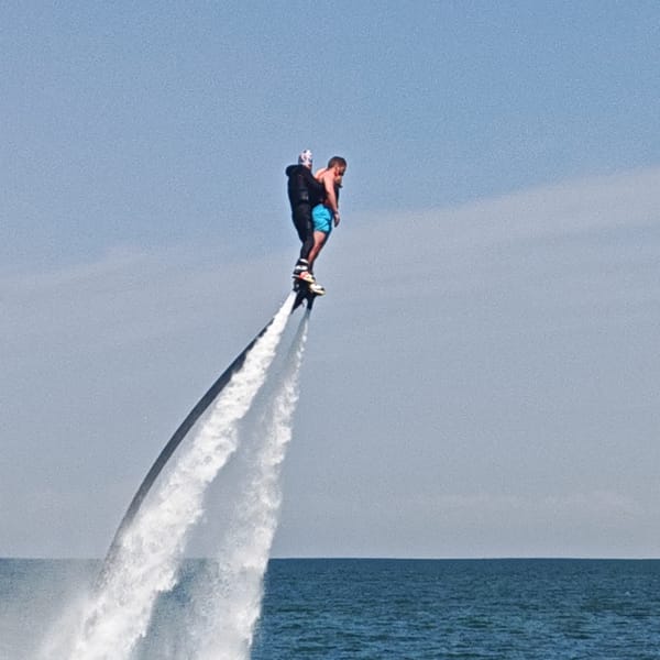 Beach resort bustling with water sports, crowds under sunny skies