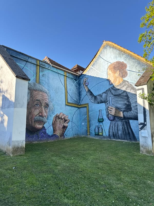Person photographed near Curie-Einstein mural in Palaiseau, France