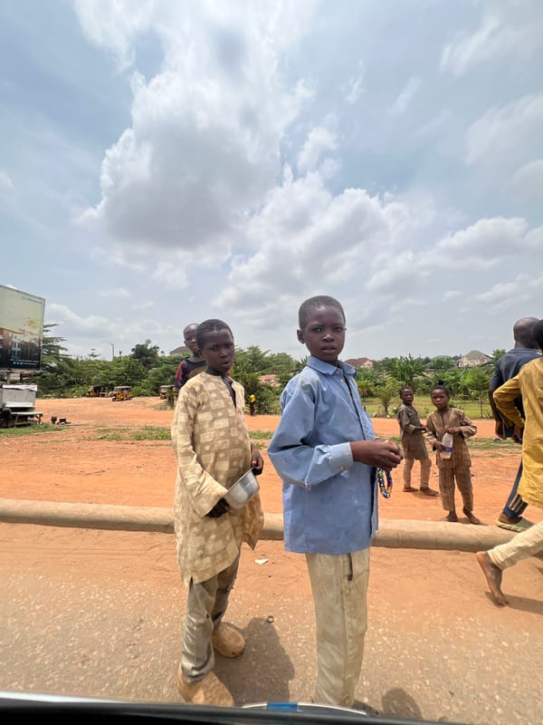 Young boys gather near dirt road in Abuja