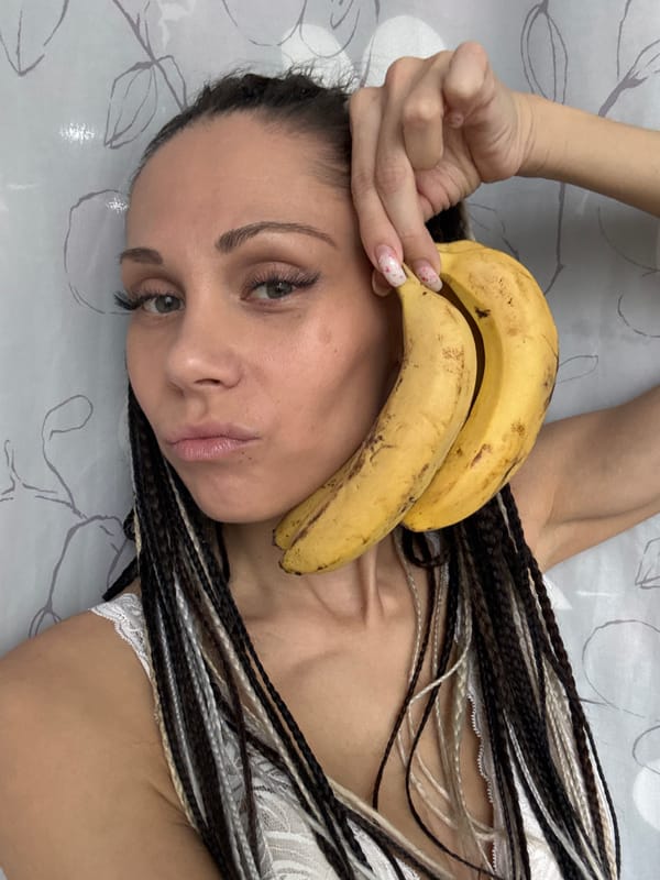 Woman poses playfully with bananas and plants in Rusanovo bedroom
