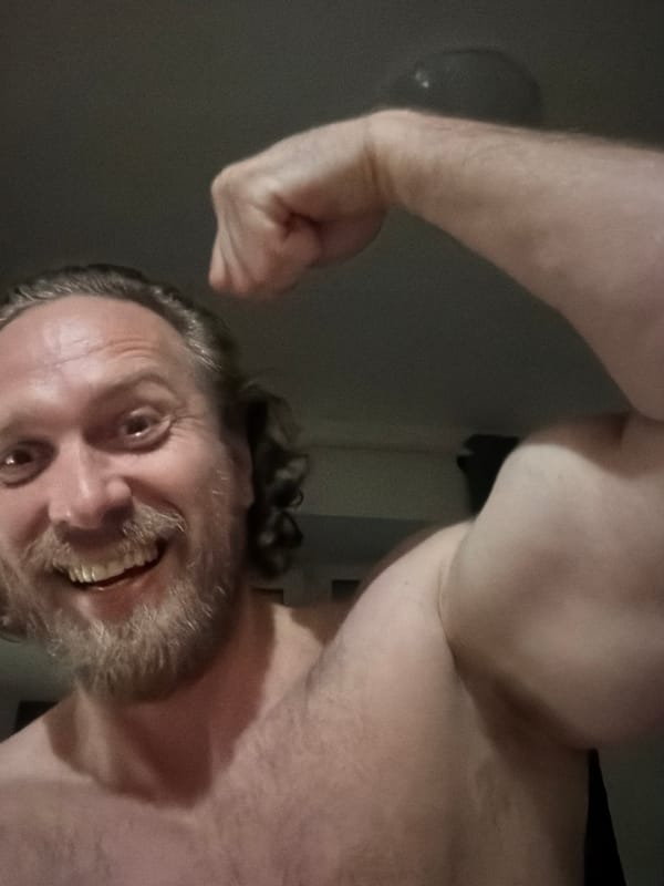 Man flexes arm indoors in Saint Petersburg