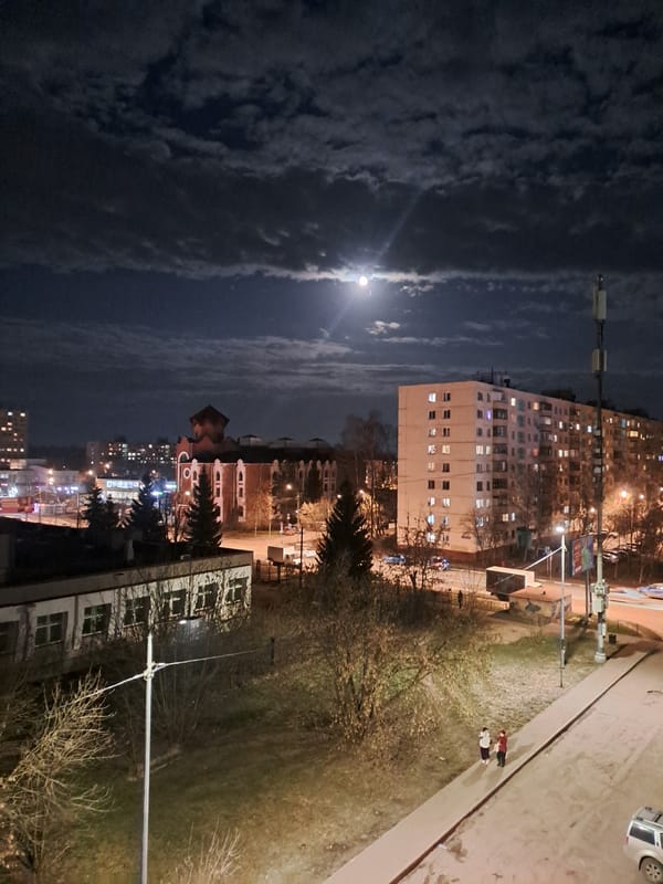 Full moon illuminates Elektrostal apartment buildings on cloudy night