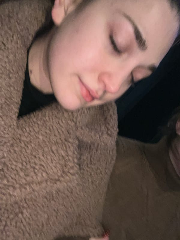 Young women share drinks and selfies during evening car ride