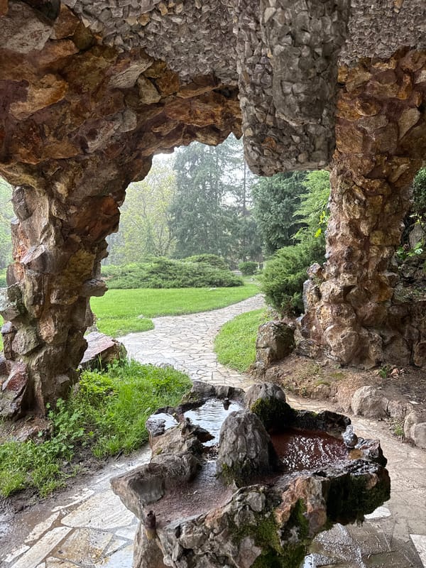 Rocky cave opening frames park view at unknown location