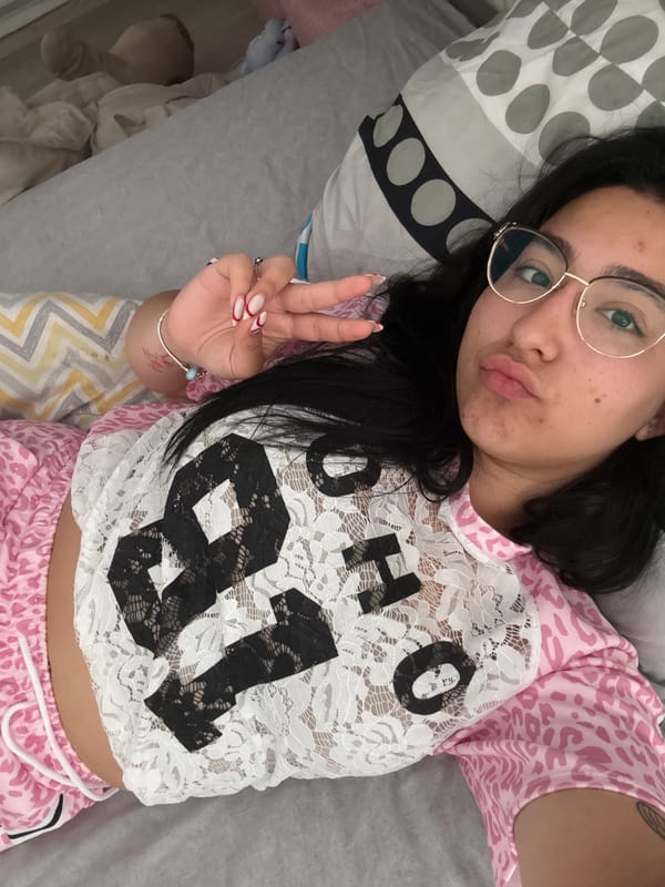 Woman makes peace sign gesture on bed in Elhovo