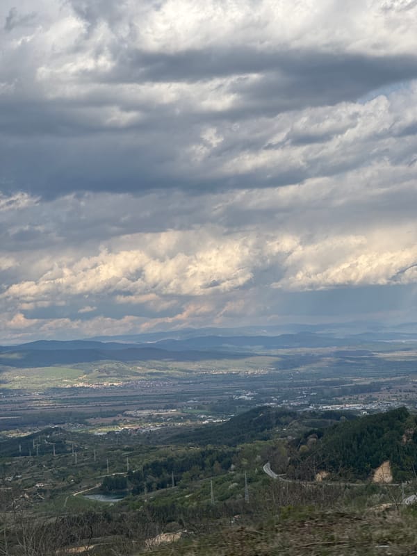 Valley landscape with buildings documented under cloudy skies