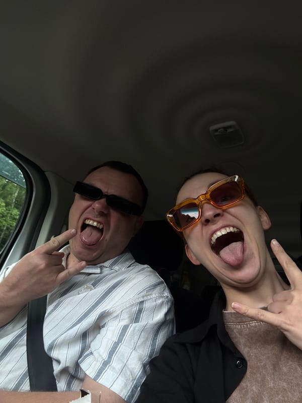 Two people make playful gestures inside vehicle in Shadki