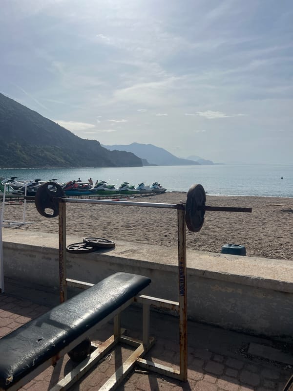 Rusty beach weightlifting bench spotted facing sea in Montenegro