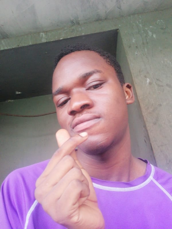 Young men pose for photos outside Enugu apartment building