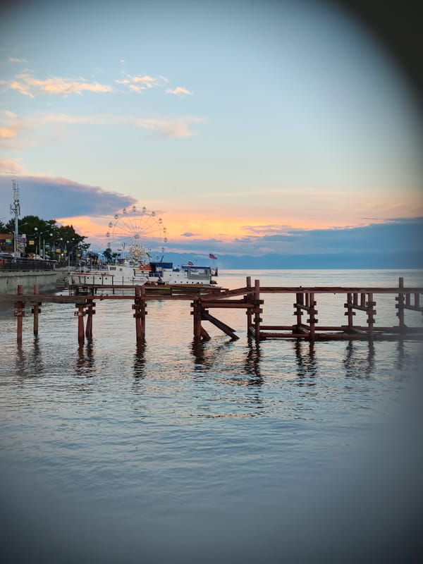Dusk at Listvyanka's waterfront: pier, calm water, worn anchor