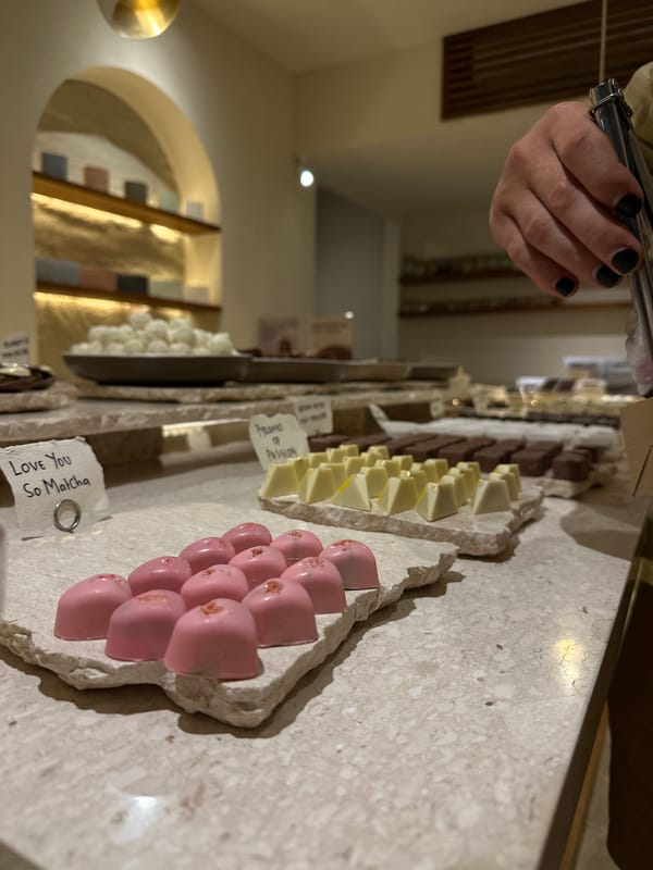 Customer selects chocolates at chocolatier store using tongs