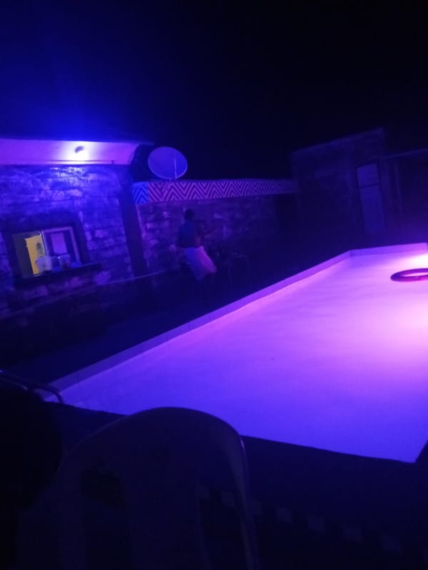 Purple-lit pool scene captured at night in Lokoja, Nigeria