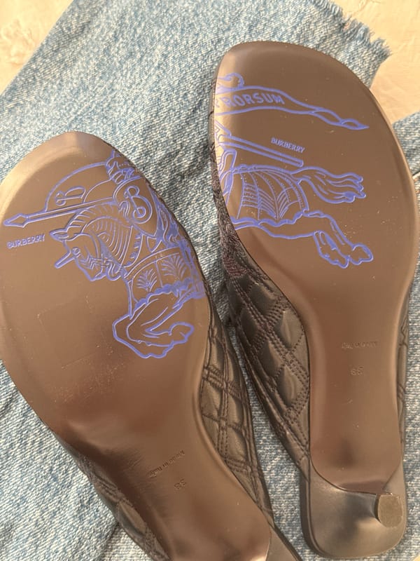 Burberry mules photographed showing brand logo and knight design