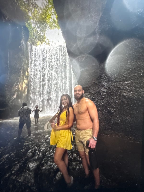 Early morning waterfall gathering includes couple posing, woman at precipice