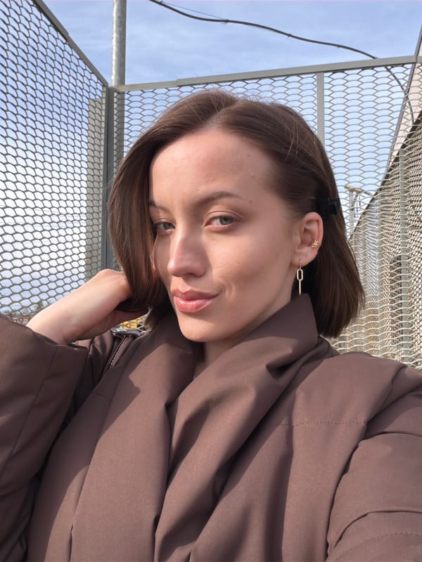 Woman photographed smiling near fence in Reshetnikovo, Russia