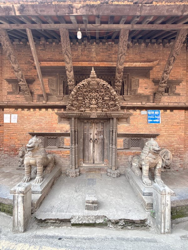 Traditional carved lions guard ornate doorway in Kathmandu