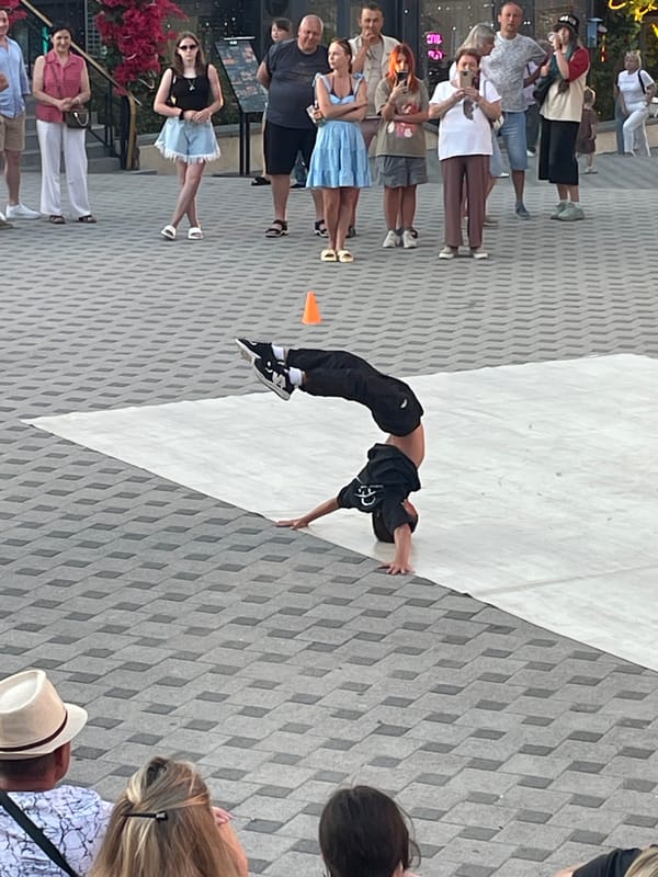 Breakdancing and a harbor sunset on a city evening