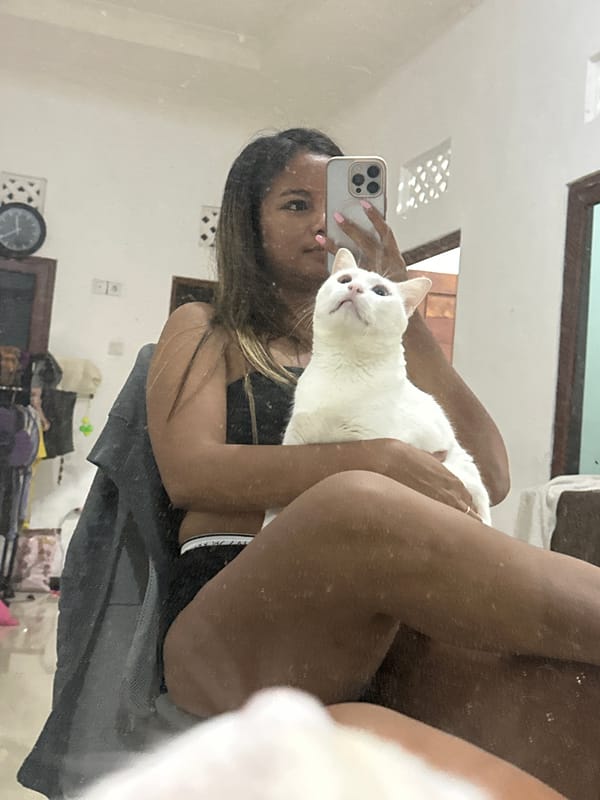 Woman documents afternoon routine with white cat in Sukawati home