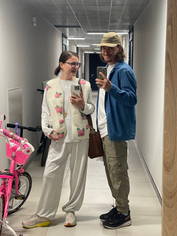 Two people captured in hallway mirror selfie
