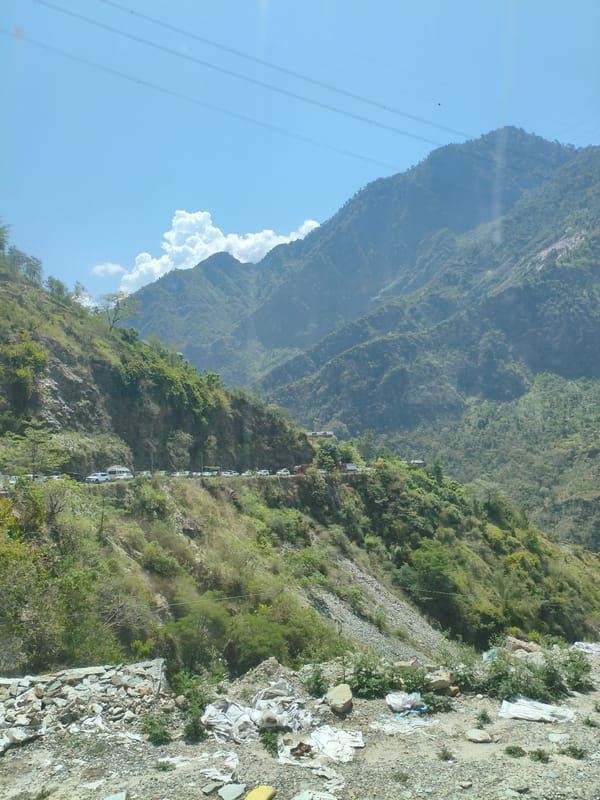 Traffic and bus travel on a winding Himachal mountain road