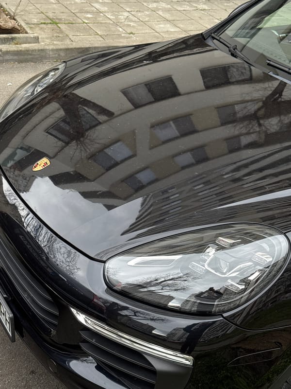 Man poses with luxury cars during morning street photography in Burgas