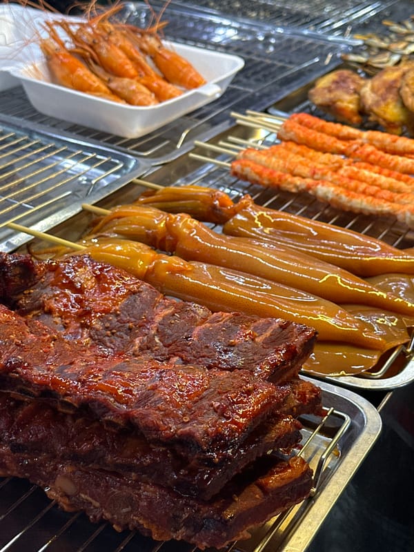 Street food vendor displays prepared dishes in Pattaya City