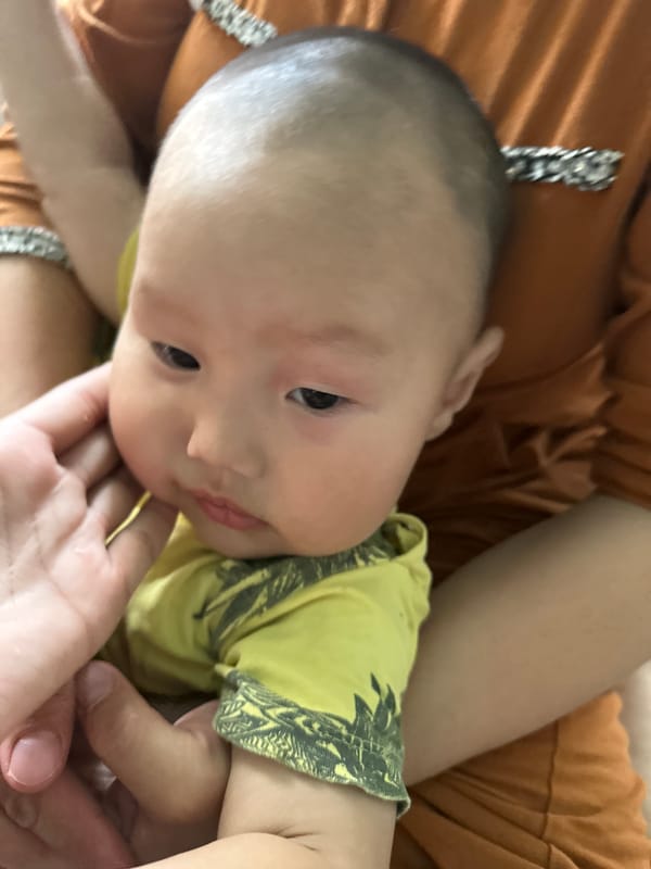 Baby gets passed around during a family visit in rural Kyrgyzstan