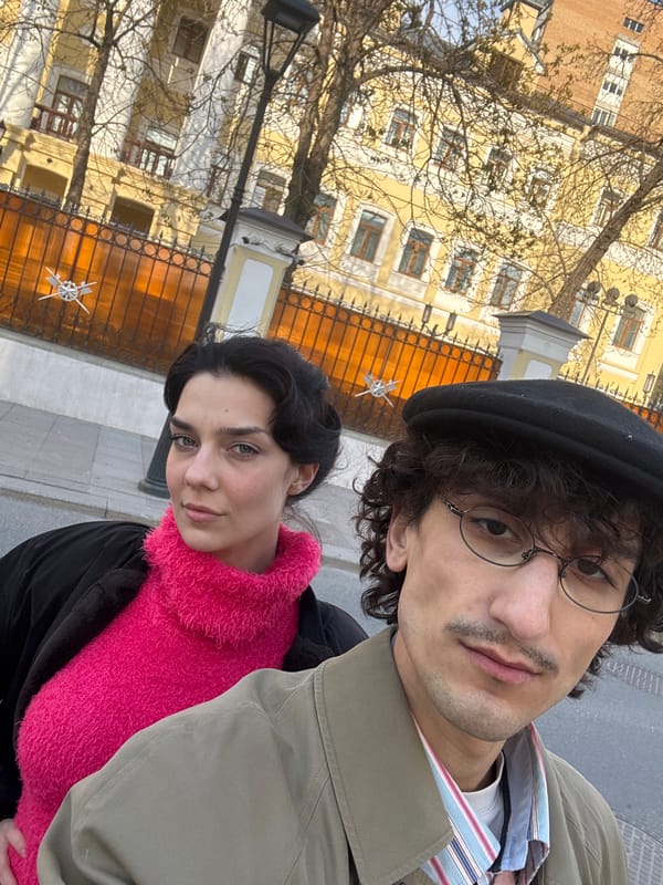 Two people take selfies on Moscow sidewalk