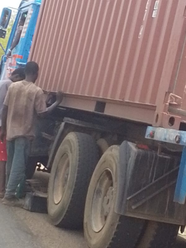 Two men inspect container truck in Tamale, Ghana