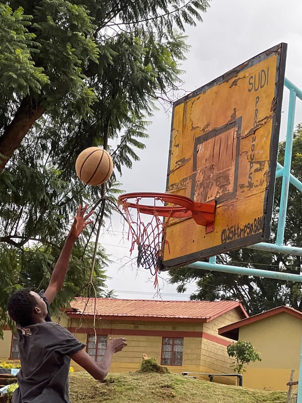 Young men play pickup basketball in Nyeri, Kenya