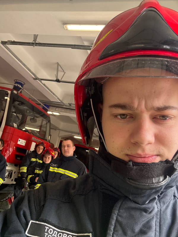Sofia firefighters pose with red fire engine indoors