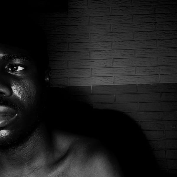 Person photographed resting near wall in Narayi, Nigeria