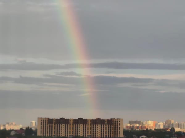 Rainbow over a cloudy city skyline