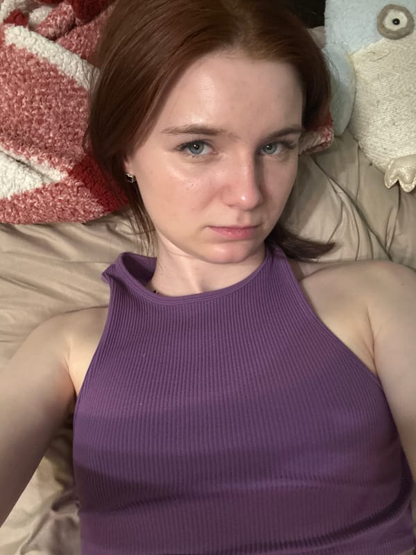 Woman rests on bed in Vsevolozhsk room