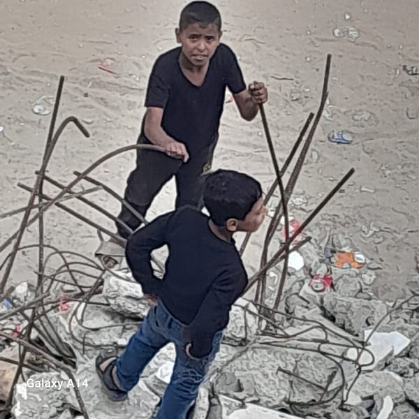 People navigate debris field amid twisted metal, rubble